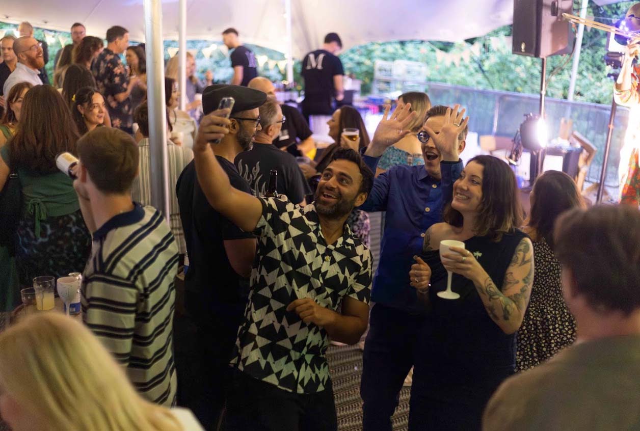 People pose for a selfie holding drinks at Legacy Event