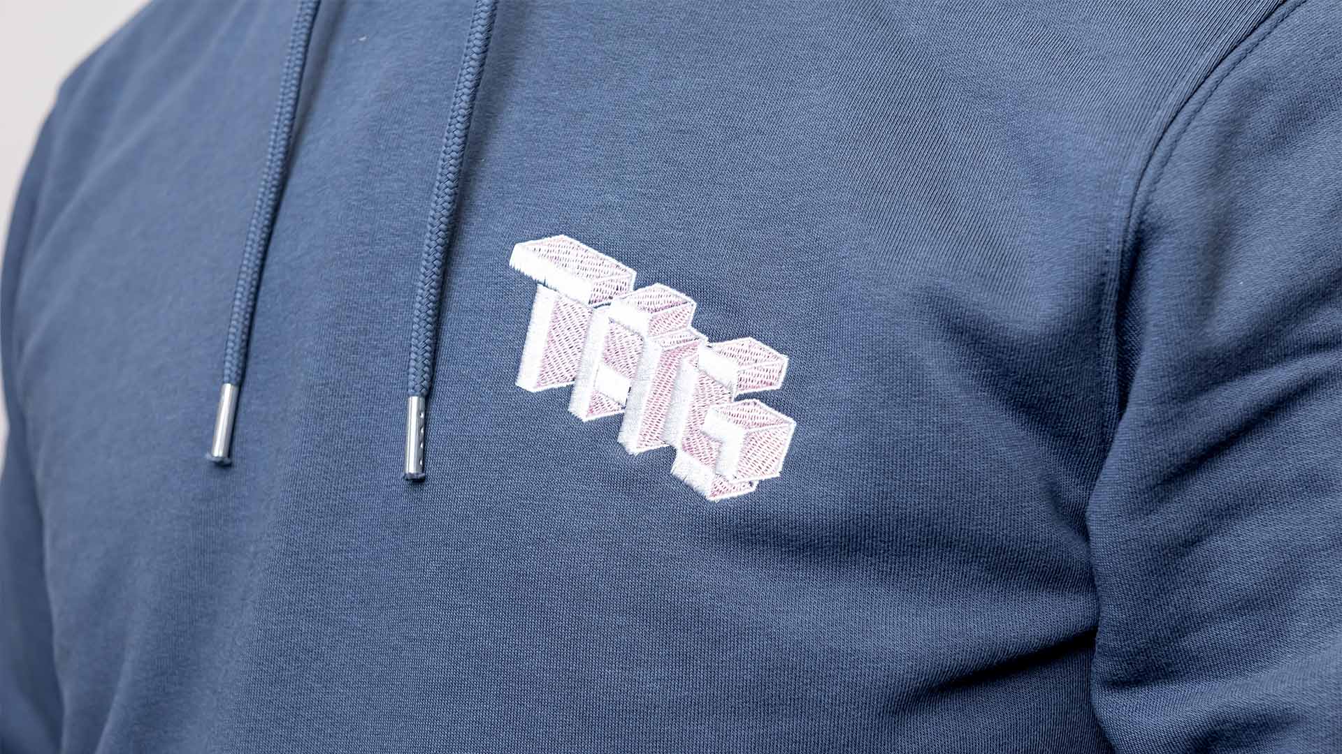 Close up of jumper with "TAG" logo